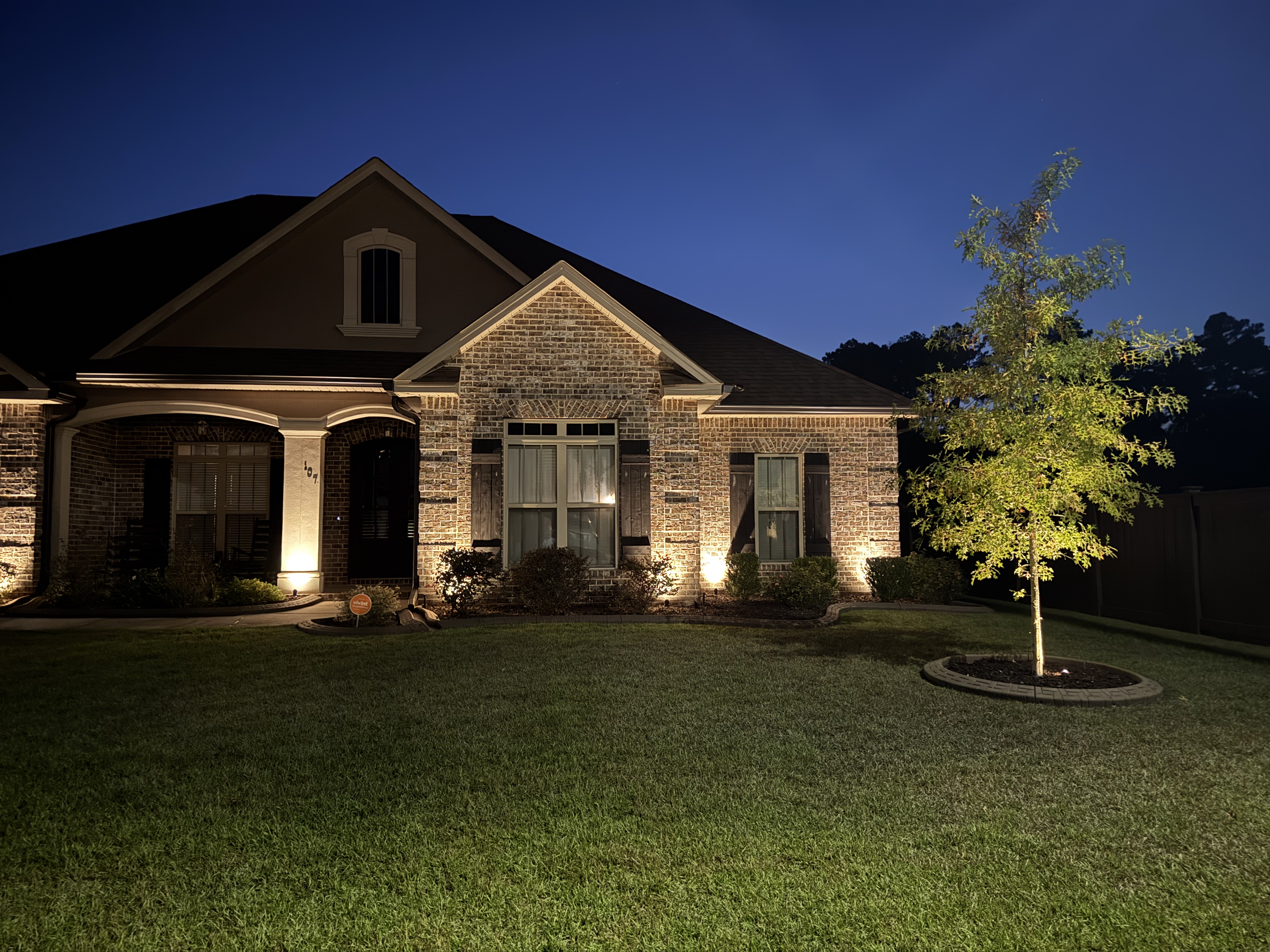 Warm white accent lighting on a two-story brick home