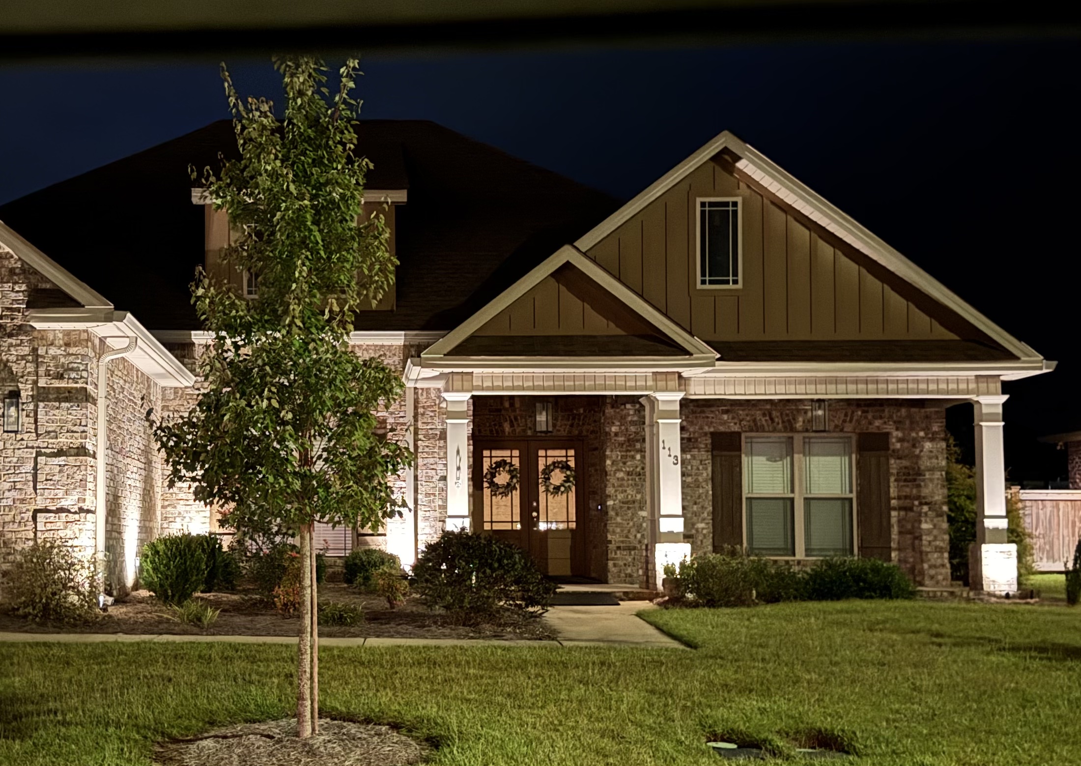 Accent lighting on a brick home at dusk
