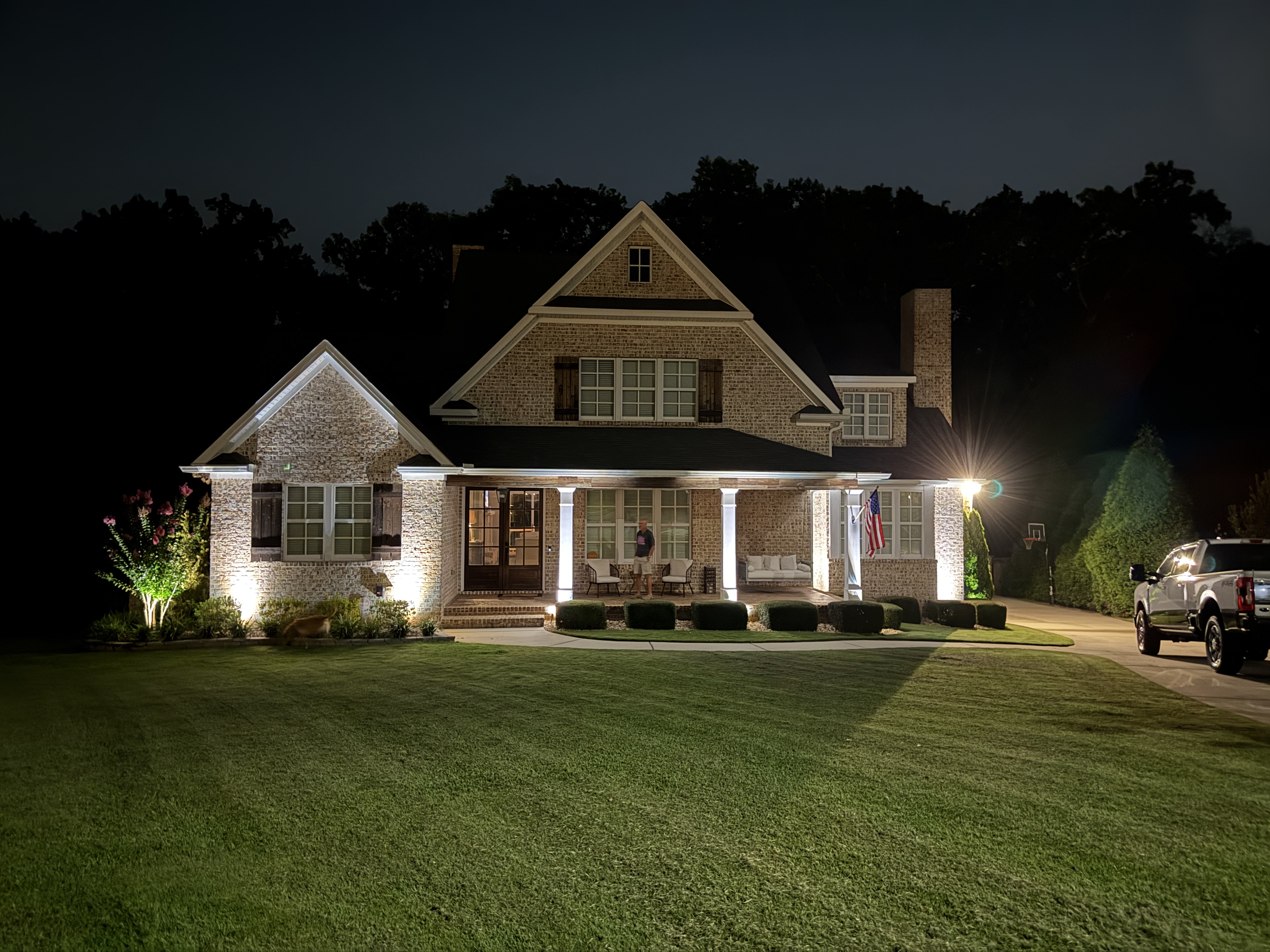 Accent lighting on a home with the homeowner on the porch